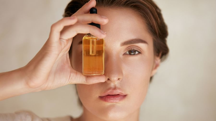A woman applying facial oil to her skin
